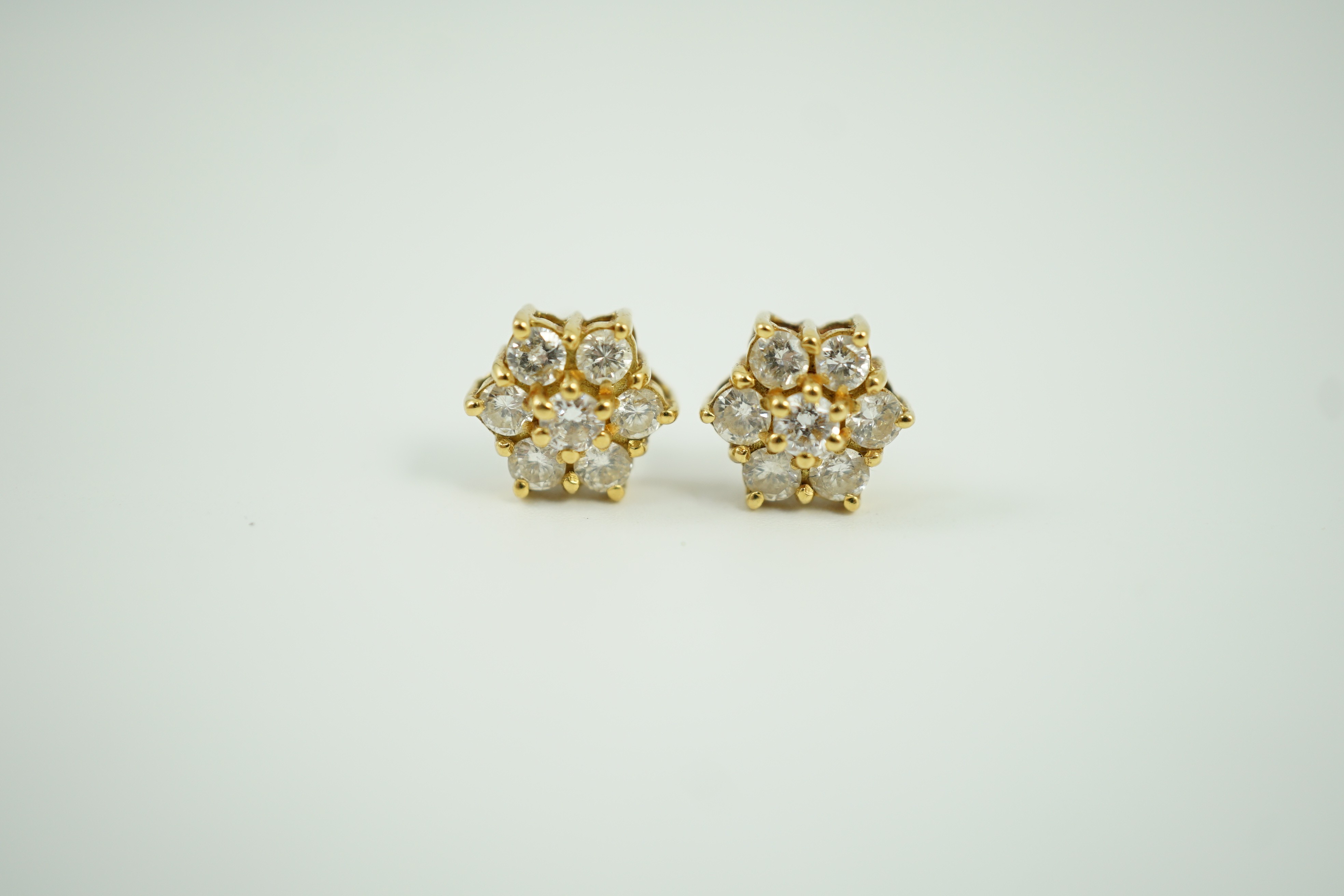 A pair of yellow metal and seven stone diamond cluster set ear studs, 7mm, gross weight 2.8 grams.